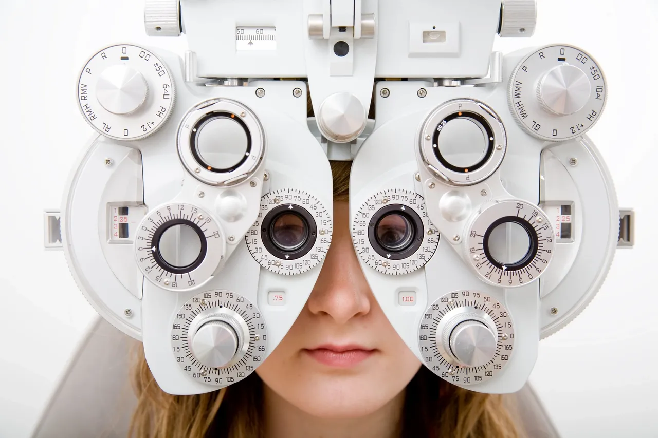 Young girl undergoing eye exam with phoropter, emphasizing importance of vision care for back-to-school success at Fox Run Eye Care in Portsmouth, NH.