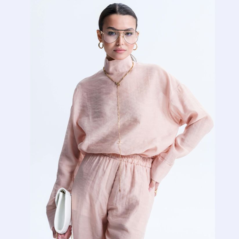 Woman wearing trendy oversized eyeglasses and a stylish pink outfit, showcasing fashionable eyeglass frames suitable for prescription lenses at Fox Run Eye Care.